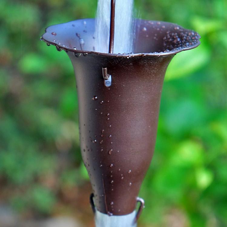 close up of Bronze Honeysuckle Rain Chain with water running through a cup